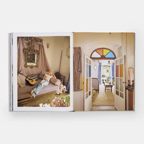 Open book showing two interior design images: a living room with a person lounging on a sofa and a colorful door.