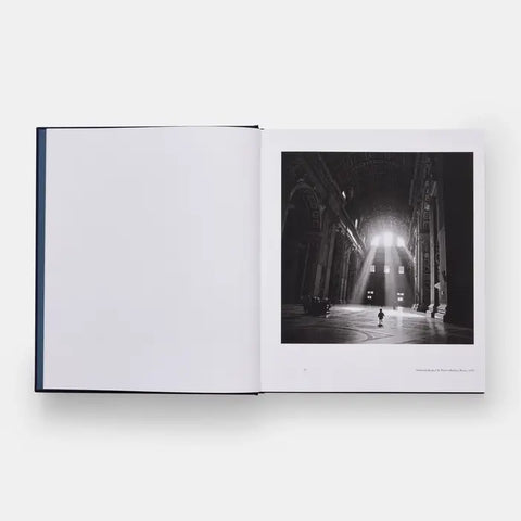 Open book displaying a black and white photograph of a cathedral interior with sunlight streaming through the windows.