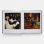 Open book showing two photographs of a formal event in an opulent room.