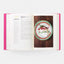 Open book with a plate of food on a wooden table