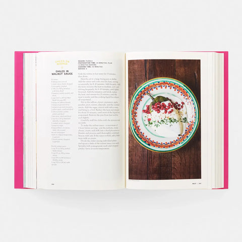 Open book with a plate of food on a wooden table