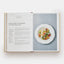 Open cookbook showing a recipe for Baked Sea Bass with Vegetables and Parsley Mayonnaise.