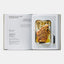 Open cookbook showing a roasted leg of lamb dish with a knife on a white background