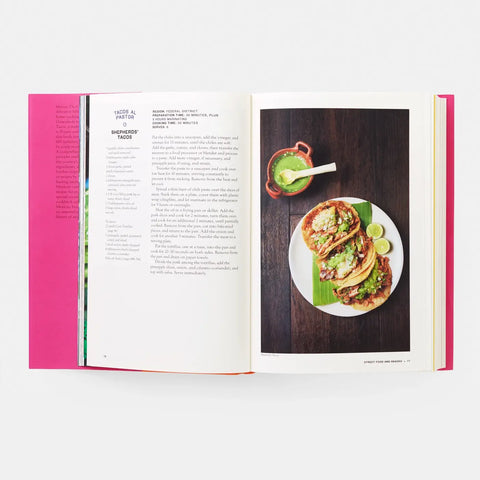 Open cookbook showing a page with a recipe and a photo of tacos on a plate.