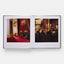 Open book showing two images: one of a formal room with red carpet and chairs, the other of a group dining in a candlelit setting.