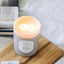 Lit Wood House candle in glass vessel viewed from above