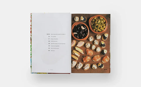 Open book showing a page with text and an illustration of food on a wooden board.