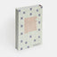 Book with decorative cover featuring tiles and text on a white background