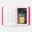 Open book with a page showing a cocktail being poured into a glass.